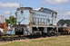 1959 Kenworth W900A - A weathered light blue train engine, marked with the number 36, sits on railroad tracks under a cloudy sky.