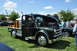 1959 Kenworth W900A - A green flatbed truck with its hood open is displayed on a grassy field next to another vehicle.