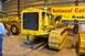 1959 Kenworth W900A - A yellow Caterpillar bulldozer is displayed indoors next to another piece of heavy equipment.