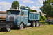 1959 Kenworth W900A - A blue dump truck with a white stripe and "38-D" marking is parked on a grassy area under a partly cloudy sky.