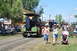 1959 Kenworth W900A - A steam tractor leads a parade of vehicles and people at an outdoor event on a sunny day.