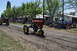 1959 Kenworth W900A - Tractors participate in a parade event, with onlookers gathered to watch.