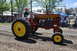1959 Kenworth W900A - A man drives a red Gibson tractor with yellow wheels during an event.
