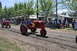 1959 Kenworth W900A - Tractors participate in a parade at an outdoor event, with spectators gathered to watch.