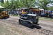 1959 Kenworth W900A - A man drives a gray crawler tractor past spectators at an outdoor event.
