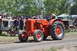 1959 Kenworth W900A - An orange tractor is driven past spectators at an outdoor event.