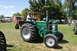 1959 Kenworth W900A - A man drives a green tractor with a Union Jack flag on its side at an outdoor event.