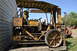 1959 Kenworth W900A - This weathered yellow tractor, likely a piece of farm equipment, sits in a field next to other machinery.