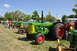 1959 Kenworth W900A - Vintage tractors are displayed outdoors on a sunny day, with a focus on a green Oliver Super 99 Diesel model.