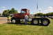1959 Kenworth W900A - Two men are measuring a Peterbilt 359 truck at an outdoor event on a sunny day.