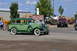 1959 Kenworth W900A - A vintage green sedan is parked outdoors with other vehicles and equipment in the background.