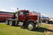 1959 Kenworth W900A - Peterbilt 359 semi-truck at an outdoor event, with a museum trailer and other vehicles present.