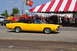 1959 Kenworth W900A - A bright yellow 1970 Dodge Charger R/T is seen at an outdoor event with fire trucks and a tent in the background.