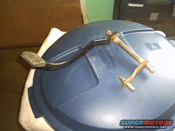 Car brake and clutch pedal assembly with mounting hardware on a blue lid