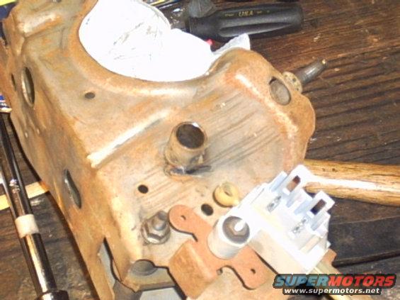 rusted metal bracket with electrical connector and some tools on a wooden surface