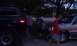 1979 Ford Bronco - A dark SUV is parked next to other vehicles under trees at dusk.