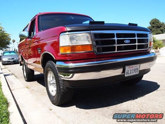 1994 Ford Bronco parked on street, another car visible in background