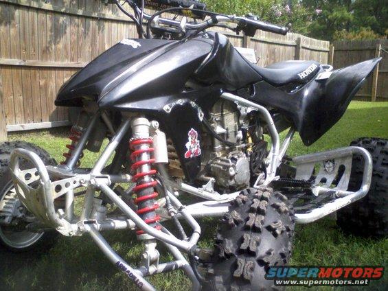 Black Honda TRX 400 EX ATV with red shocks and silver frame, parked on grass