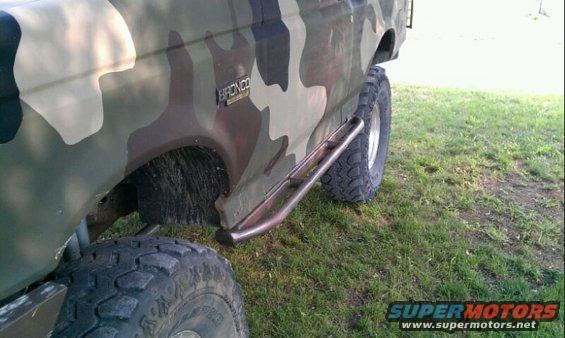 1995 Ford Bronco side view with camouflage paint and aftermarket rock sliders
