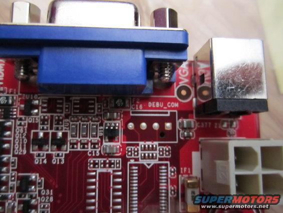 Close-up of a computer motherboard with VGA and USB ports, and various electronic components
