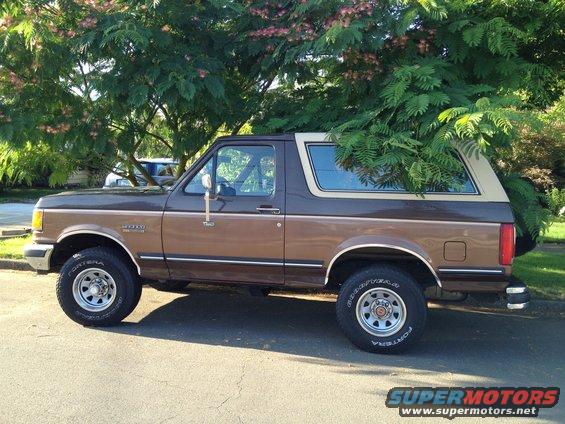 Side view of a brown 1991 Ford Bronco parked under a tree
