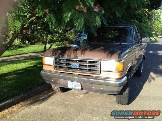 1987 Ford F-150 parked on a street, front view. Brown and tan paint