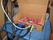 1963 Ford Falcon - Computer circuit board with VGA, USB, and audio cables connected, resting in a cardboard box.