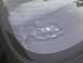 2003 Ford Crown Victoria - A car wheel with a silver emblem is visible through the rear window of a vehicle.