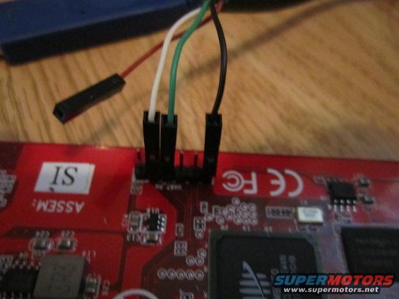 Circuit board with wires connected to pins. Text reads 'ASSM: IS' and 'CE FC'