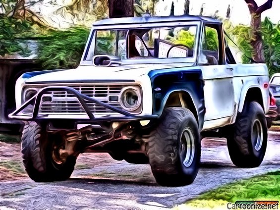 White and blue Ford Bronco with large tires and a front brush guard, viewed from a low front angle