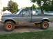 1991 Ford F-250 - This 1991 Ford F-250 pickup truck features a two-tone gray paint scheme and distinctive orange-colored wheel rims.