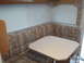 1967 Ford Mustang - The interior of an RV shows a dinette area with upholstered seating and blinds on the windows.