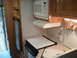 1967 Ford Mustang - The interior of an RV shows a compact kitchen area with appliances and cabinetry.