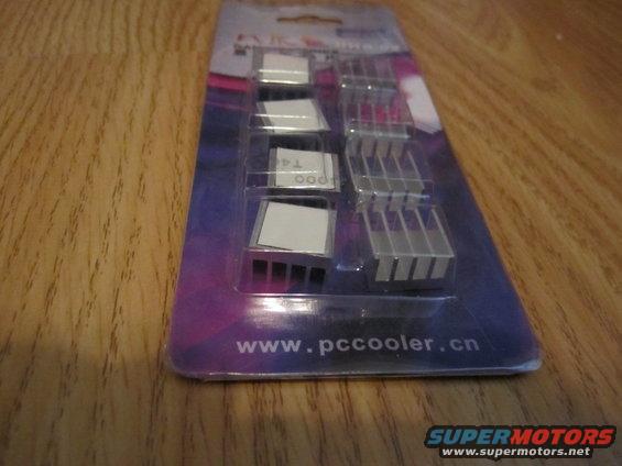 Package of aluminum heatsinks with adhesive backing on a wooden surface