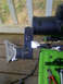 1989 Ford Bronco - A metal part is shown with a shiny rod and a speed square, against a green background.