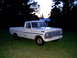 1967 Ford F-250 - A white 1967 Ford F-250 pickup truck is seen from a three-quarter front view, parked in a grassy area at dusk.