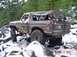 1989 Ford Bronco - A Ford Bronco navigates a rocky, snow-covered trail in a wooded area.