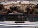 1967 Ford F-250 - The engine bay of a white 1967 Ford F-250 shows significant rust and wear, with the engine and radiator clearly visible.