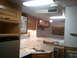 1967 Ford Mustang - The interior of a camper features a kitchen area with a microwave and sink, adjacent to a sleeping area.