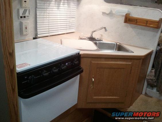 RV interior with sink, faucet, and stove