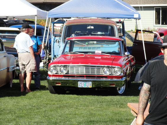 1964 Ford Fairlane front view, license plate 251 CEV, parked under a tent with a blue truck behind it