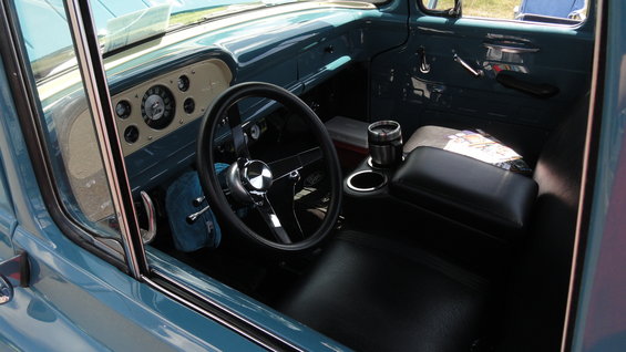 Interior of a blue 1956 Ford F-100 truck, showing dashboard and seats