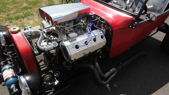 Hot rod engine bay with V8 engine, chrome air intake, and exhaust headers