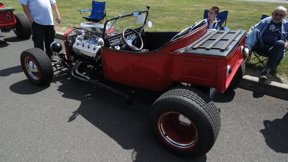 red hot rod with exposed engine, custom bed, and chrome accents