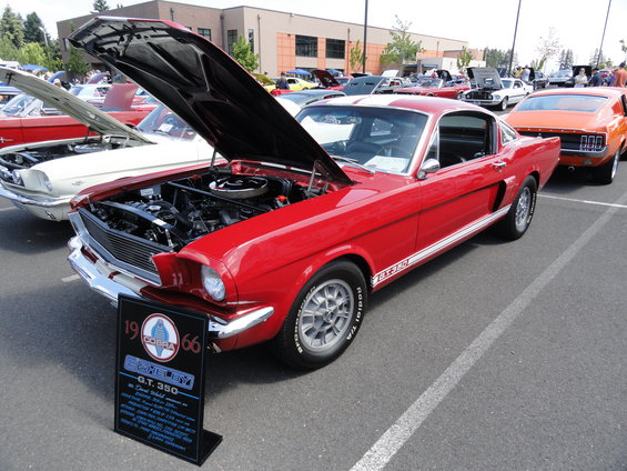 Red 1966 Shelby GT 350 with hood open, white racing stripes, and side stripe