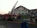 2006 Ford E350 - Emergency responders are on the scene of a fire with a damaged building and a fire truck.