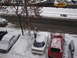 1995 Ford Probe - Cars are parked on a snow-covered street, with a person clearing snow from a vehicle.