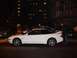 1995 Ford Probe - A white 1995 Ford Probe is parked on a street at night with a person standing next to it.