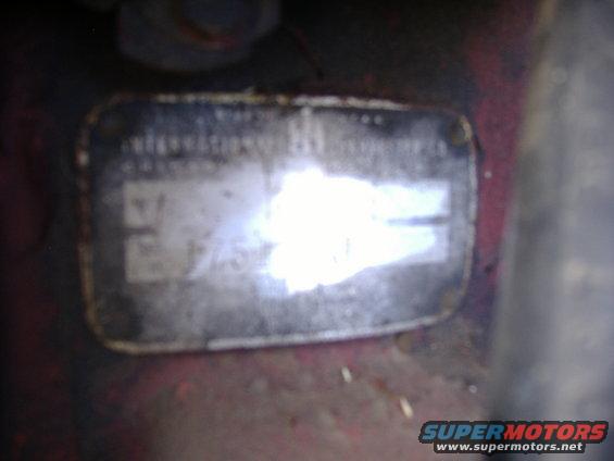 Close-up of a metal identification plate with faded text and numbers