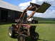 1988 Ford Bronco - Tractor with front loader in front of a barn with a cornfield in the background.